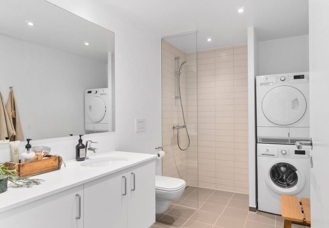 Rummeligt og praktisk indrettet badeværelse med vaskesøjle fra Electrolux.